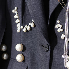 Blazer de botonadura sencilla con cuello de solapa, ribete sin rematar y detalle de alfiler único adornado con perlas