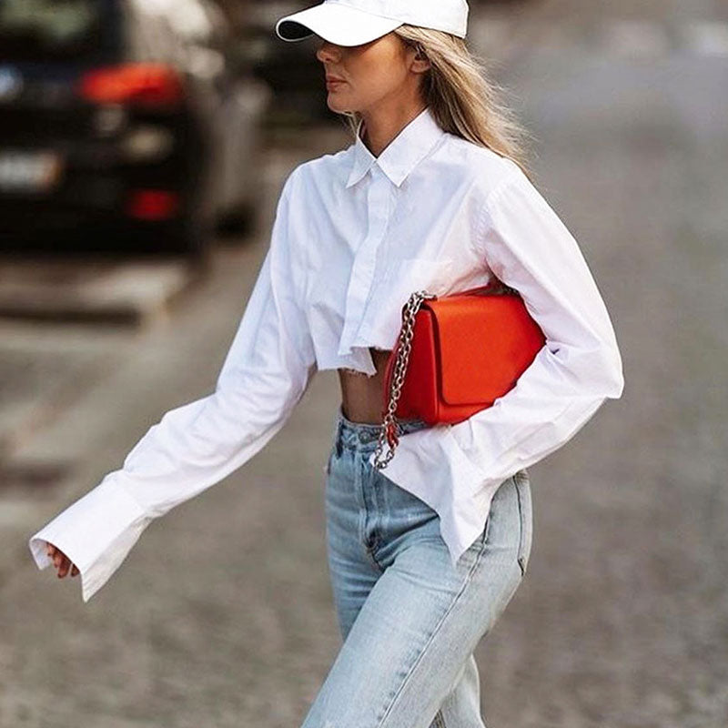 Camisa corta asimétrica con cuello, botones y manga larga con detalle de bolsillo y dobladillo sin rematar